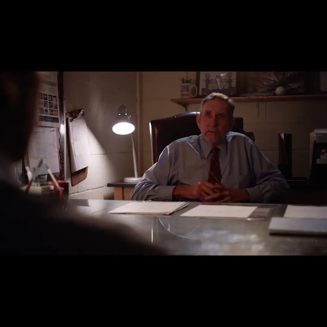 Three people gathered around a table as one signs documents