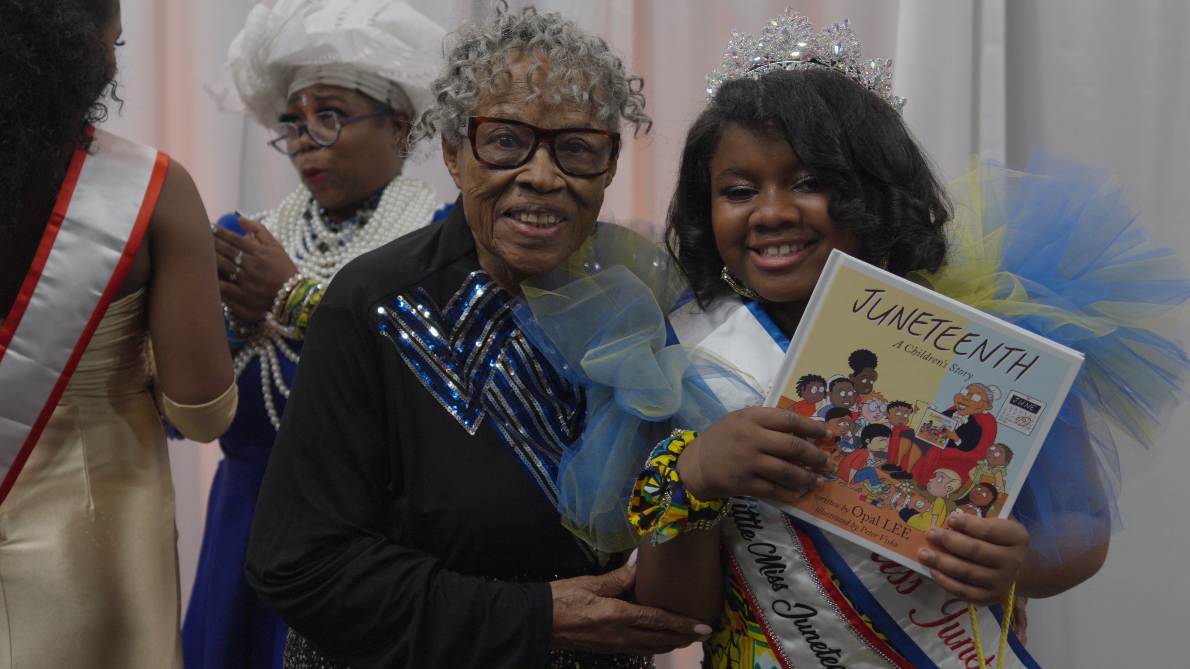 Dr. Opal Lee with young girl holding a Juneteenth children's book