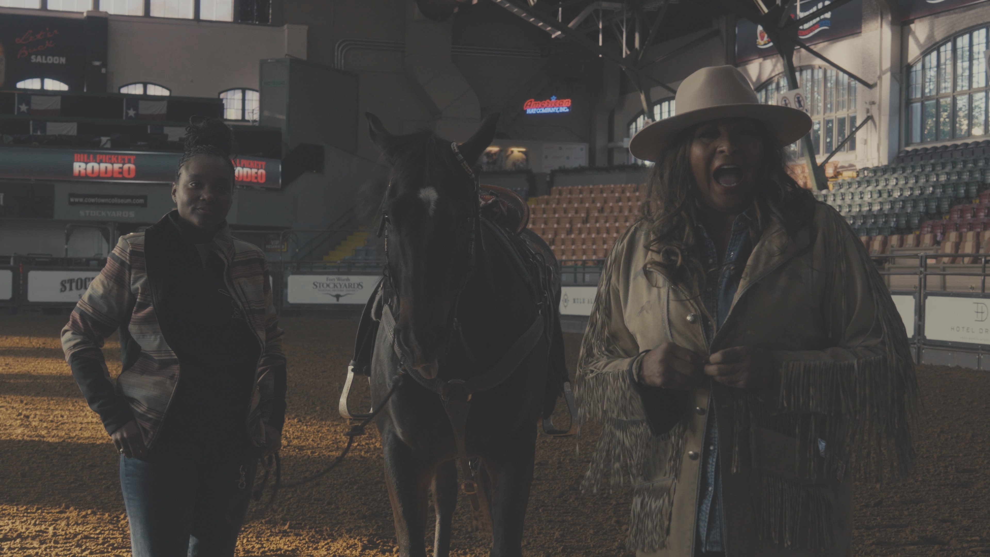 Two women and a horse inside the Bill Pickett Rodeo arena at Fort Worth Stockyards