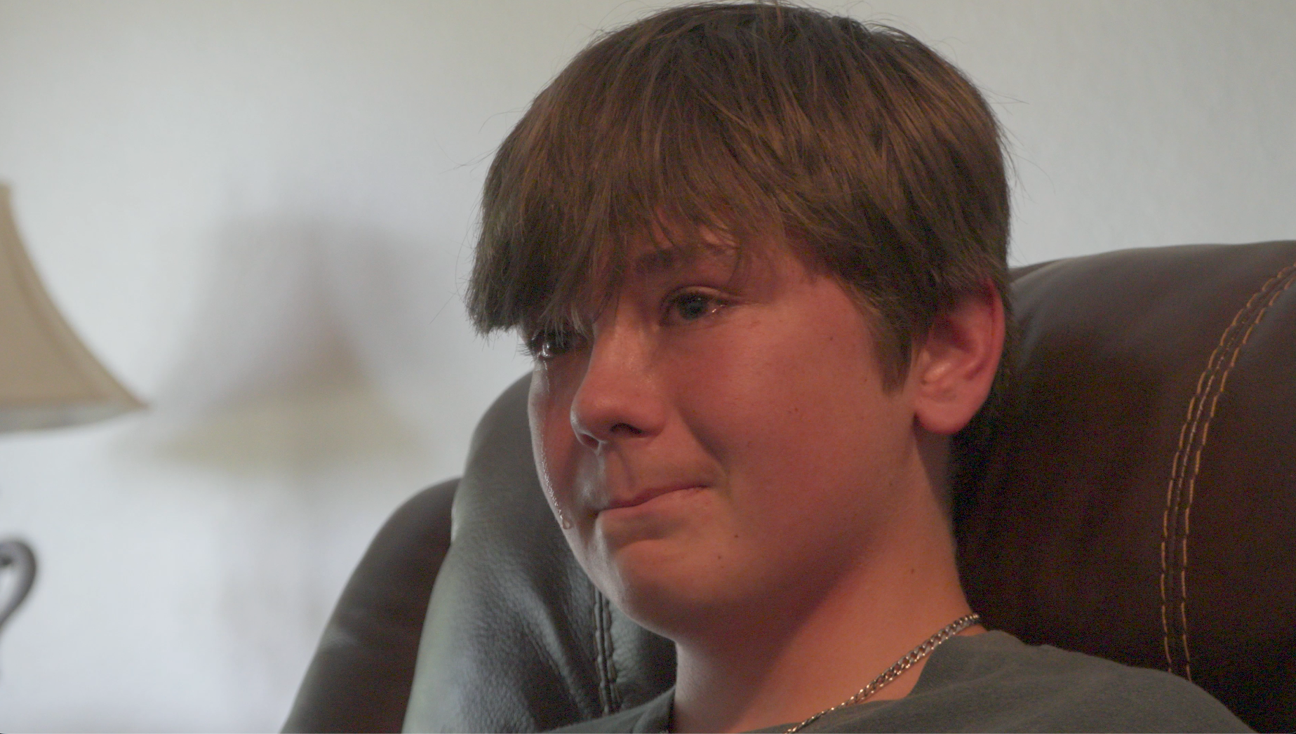 Young man crying in recliner chair during interview
