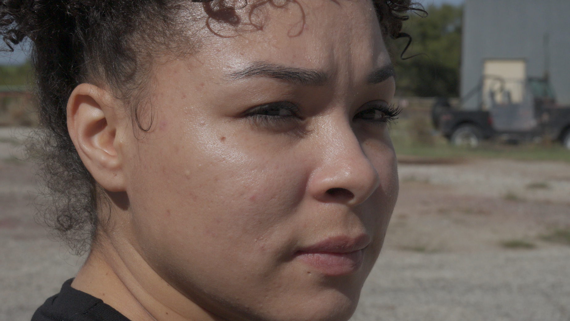 Close-up portrait of young woman outdoors looking off-camera